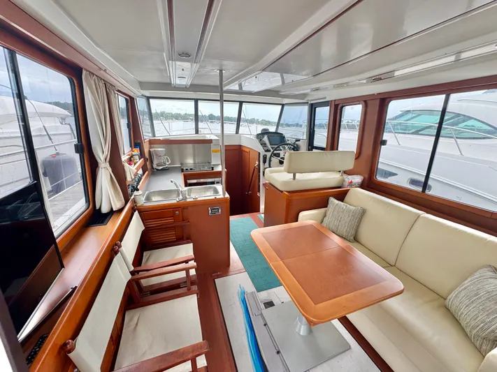 Amour Yacht Photos Pics 2018 Beneteau Swift Trawler 34 interior with kitchen, seating, and helm station.