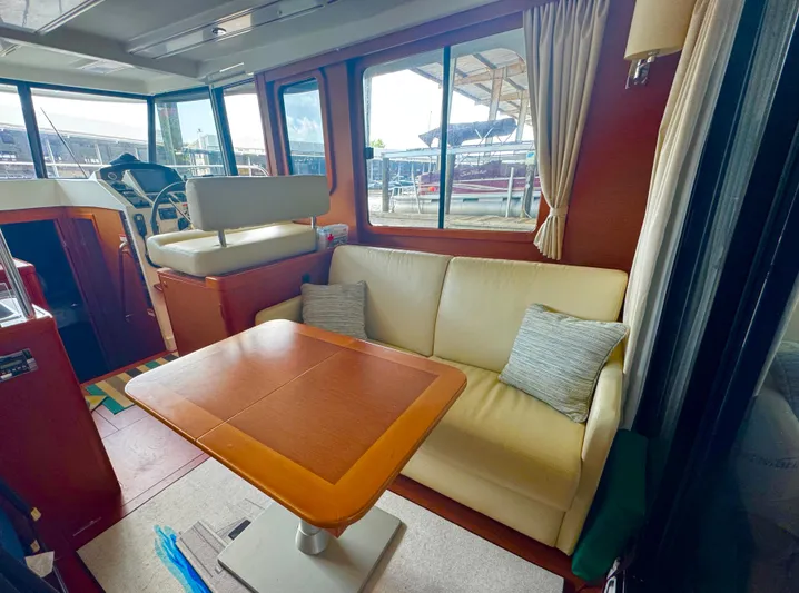 Amour Yacht Photos Pics Interior of 2018 Beneteau Swift Trawler 34 with sofa, table, and helm station.