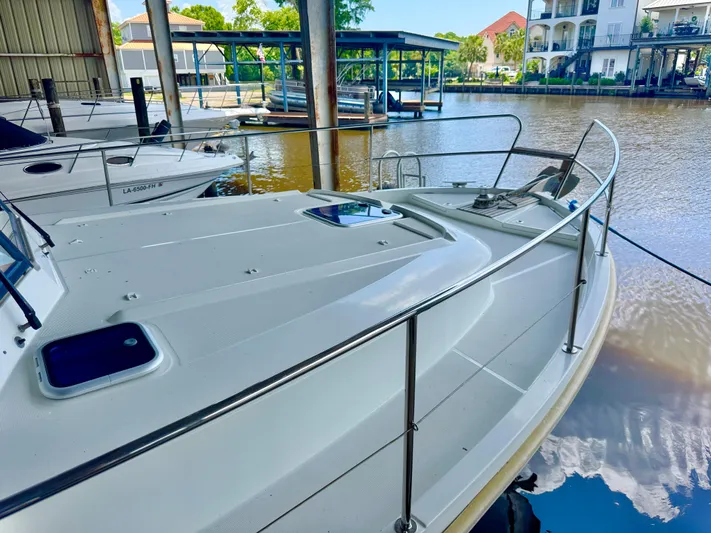 Amour Yacht Photos Pics 2018 Beneteau Swift Trawler 34 docked in a marina, surrounded by calm waters.