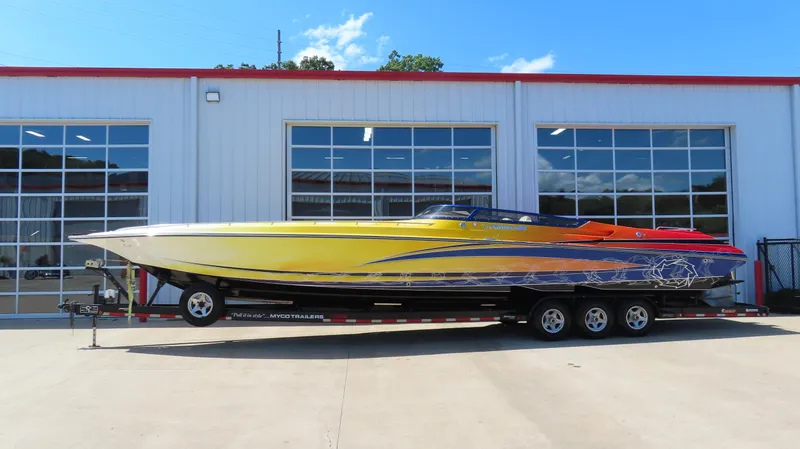  Yacht Photos Pics 2007 Fountain 42 Lightning speedboat on trailer, vibrant yellow and orange design, parked outside garage.