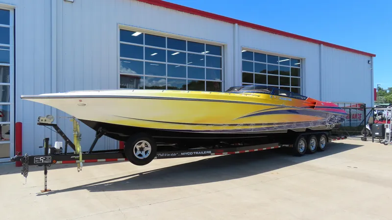  Yacht Photos Pics 2007 Fountain 42 Lightning speedboat on trailer, vibrant yellow and orange design, parked outside a building.