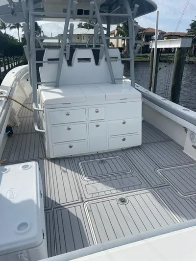  Yacht Photos Pics 2018 Regulator 41 boat deck with storage compartments and seating, docked by waterfront homes.