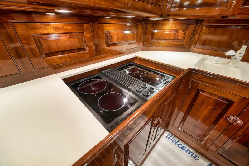 Knot Now Yacht Photos Pics Luxurious 1997 Miller Marine Custom Carolina yacht kitchen with sleek wood cabinetry and modern stovetop.