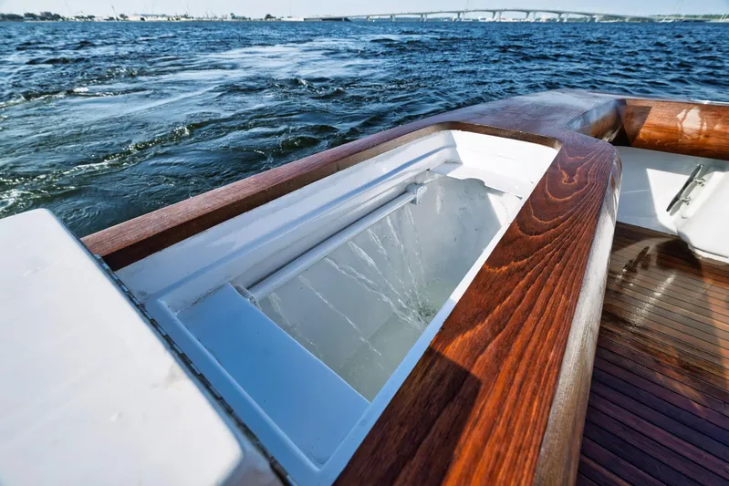 Knot Now Yacht Photos Pics 1997 Miller Marine Custom Carolina boat with wooden deck and open storage compartment on water.