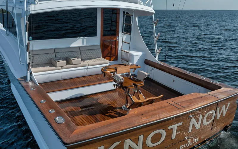 Knot Now Yacht Photos Pics 1997 Miller Marine Custom Carolina yacht with wooden deck and seating, named "Knot Now," on the water.