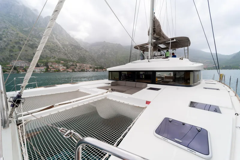  Yacht Photos Pics 2015 Lagoon 52 F catamaran sailing in scenic mountainous waters.