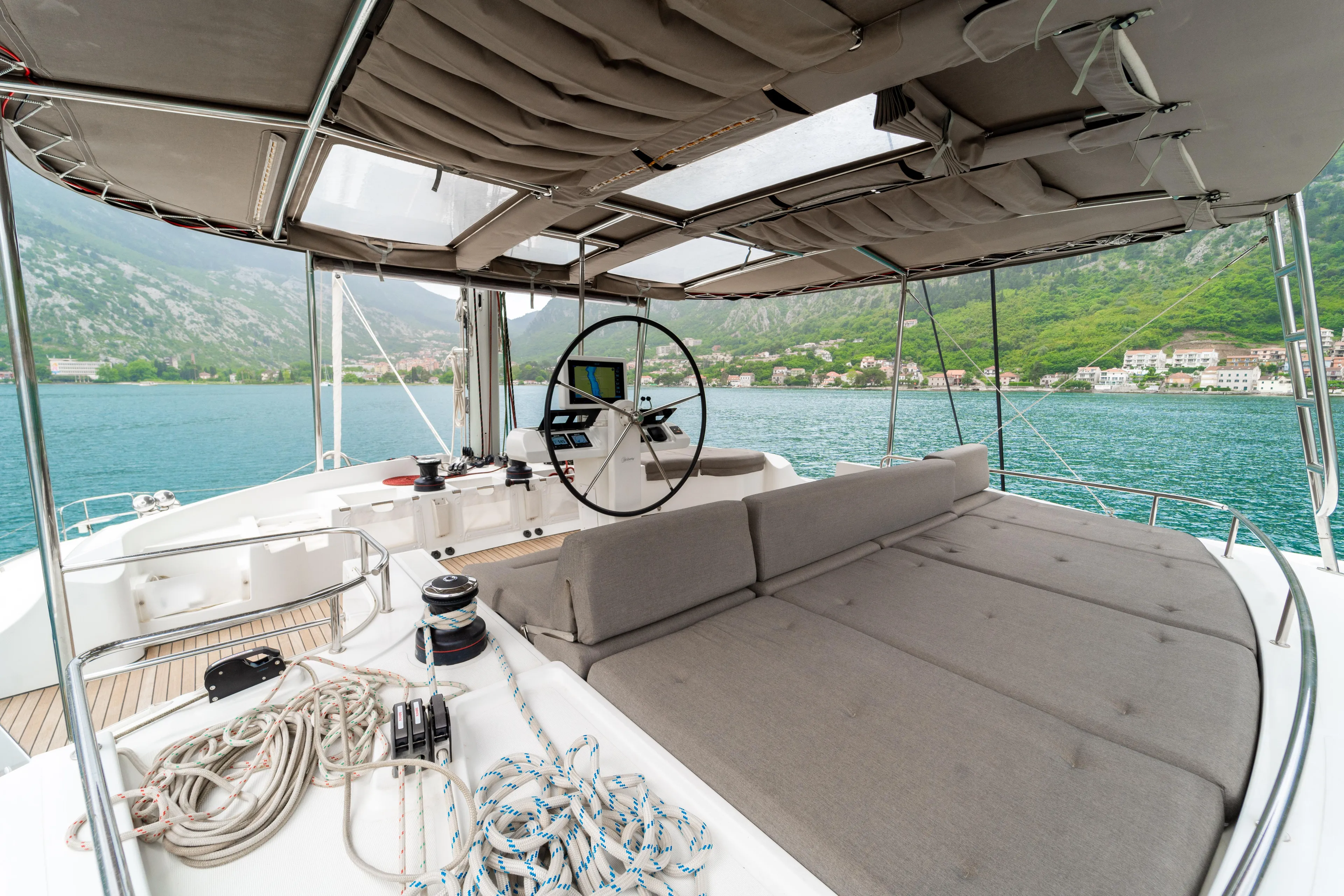 Yacht Photos Pics Luxurious 2015 Lagoon 52 F yacht deck with helm, overlooking serene waters and lush mountains.