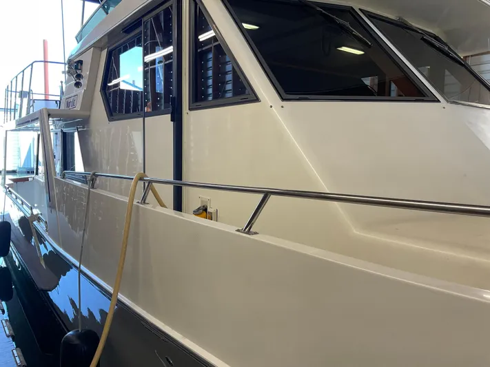  Yacht Photos Pics 1991 Nordic Pilothouse boat in a dock, showcasing sleek design and windows.