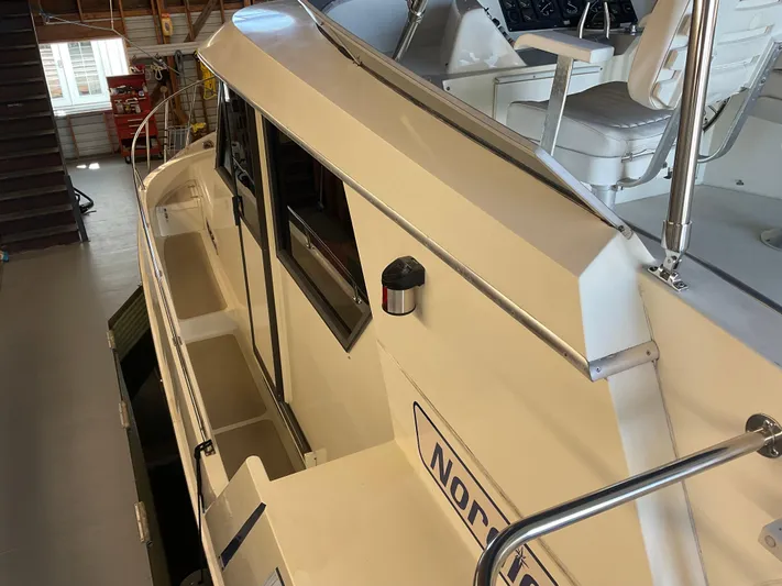  Yacht Photos Pics 1991 Nordic Pilothouse boat interior with white seating and railing in a garage setting.