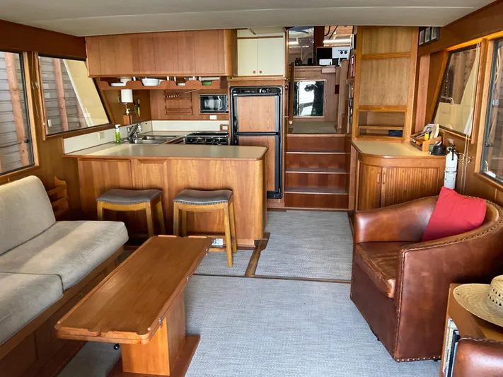  Yacht Photos Pics Interior of a 1991 Nordic Pilothouse boat with cozy seating and wooden furnishings.