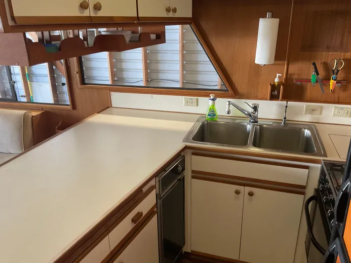  Yacht Photos Pics 1991 Nordic Pilothouse kitchen with dual sinks, white countertops, and wooden cabinets.