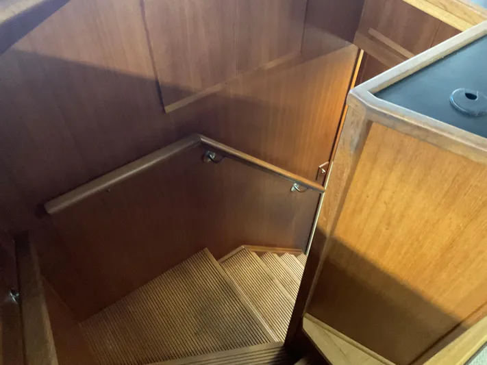  Yacht Photos Pics Staircase inside 1991 Nordic Pilothouse boat with wooden paneling and handrail.