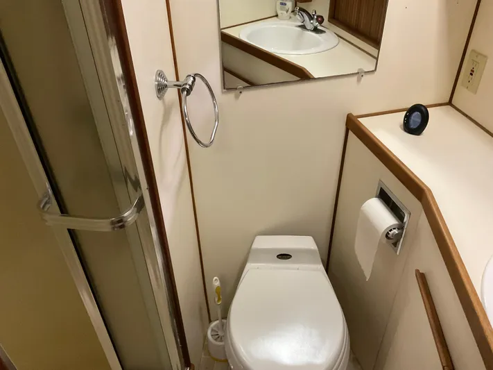  Yacht Photos Pics Compact bathroom in a 1991 Nordic Pilothouse, featuring a toilet, sink, and shower.