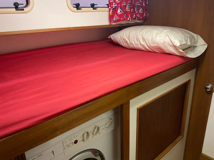 Yacht Photos Pics Bunk bed with red bedding in 1991 Nordic Pilothouse boat interior.