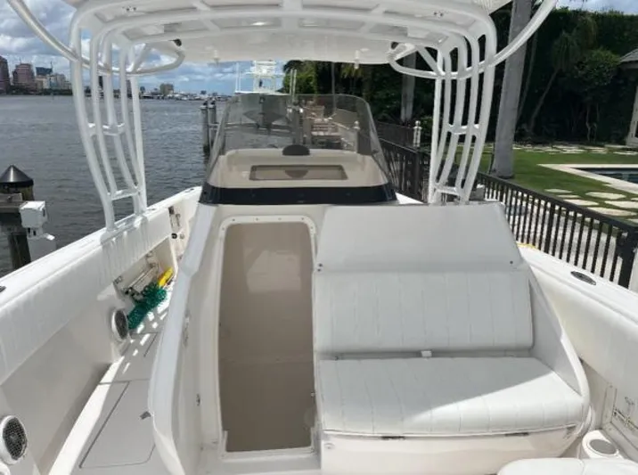 Gin Fizz Yacht Photos Pics 2012 Intrepid 327 boat with white seating, docked by a waterfront.