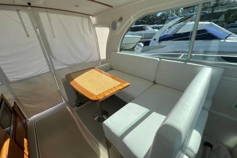  Yacht Photos Pics 2024 Back Cove 34O interior with white seating and wooden table.
