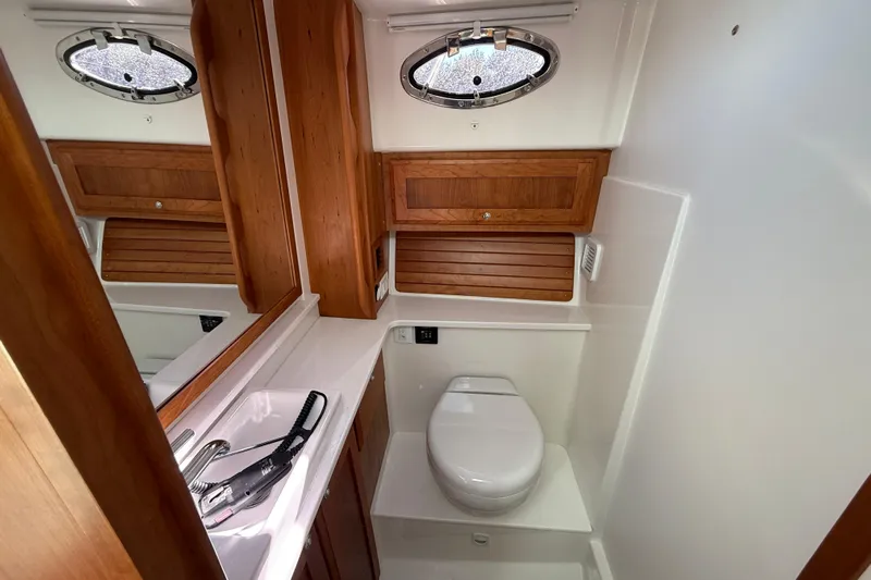  Yacht Photos Pics 2024 Back Cove 34O yacht bathroom with wooden cabinetry and modern fixtures.