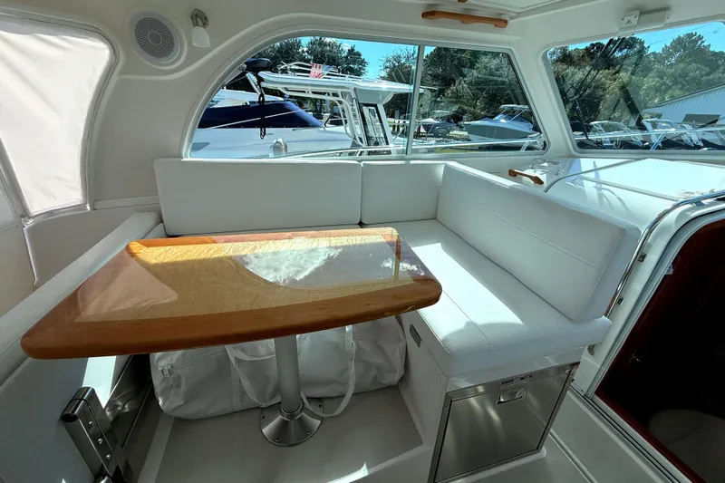  Yacht Photos Pics 2024 Back Cove 34O interior with white seating and wooden table.