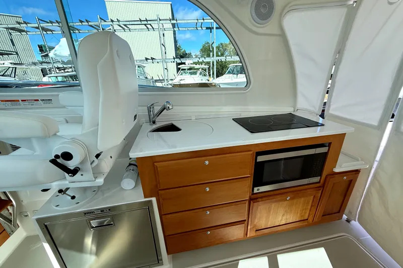  Yacht Photos Pics 2024 Back Cove 34O yacht interior with kitchenette, featuring stove, microwave, and seating.