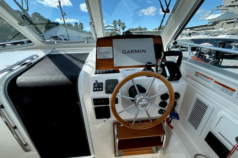  Yacht Photos Pics 2024 Back Cove 34O helm with Garmin navigation, wooden steering wheel, and modern controls.