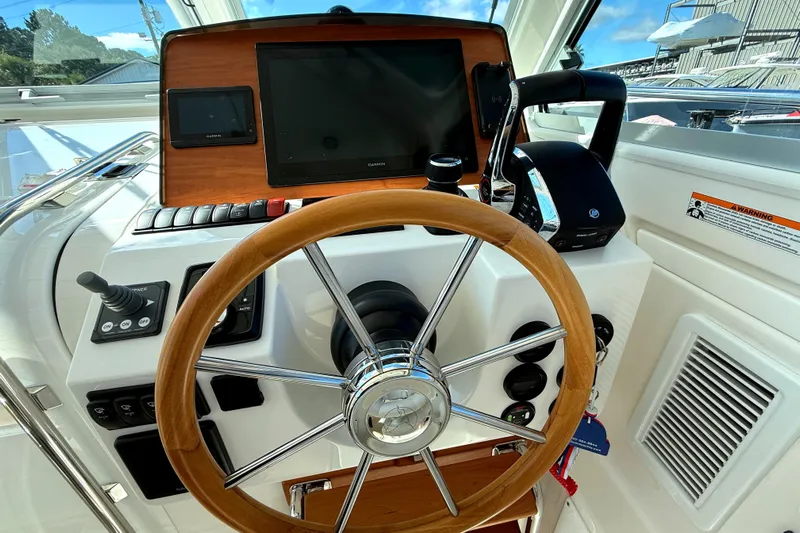  Yacht Photos Pics Helm of 2024 Back Cove 34O boat with wooden steering wheel and navigation controls.