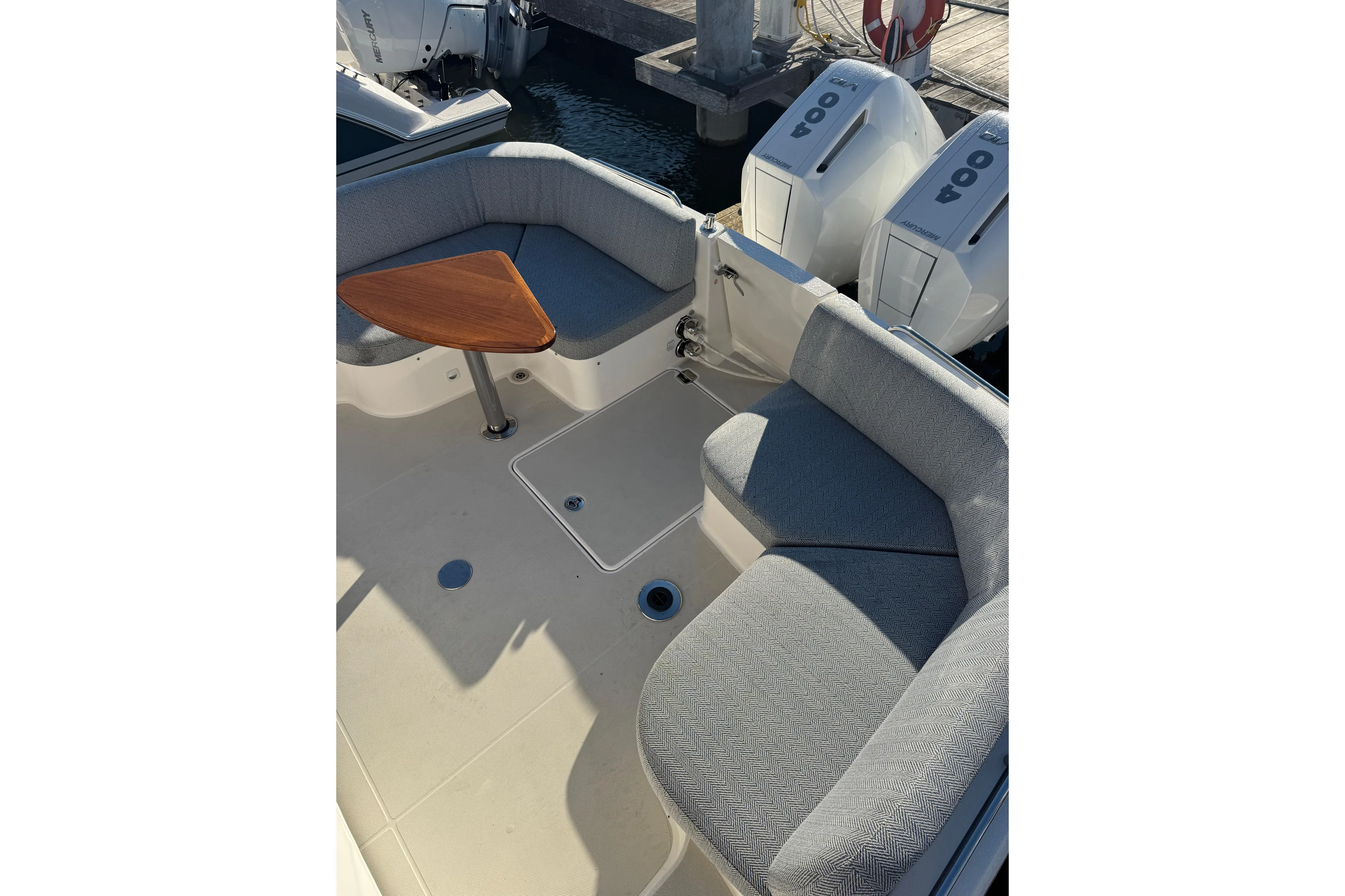  Yacht Photos Pics 2024 Back Cove 34O boat interior with cushioned seating and wooden table.