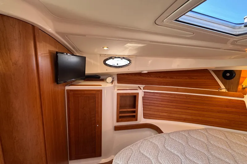  Yacht Photos Pics 2024 Back Cove 34O cabin interior with wood paneling and mounted TV.