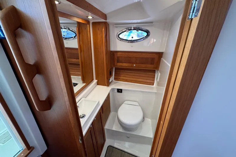  Yacht Photos Pics 2024 Back Cove 34O yacht bathroom with wooden cabinetry and modern fixtures.