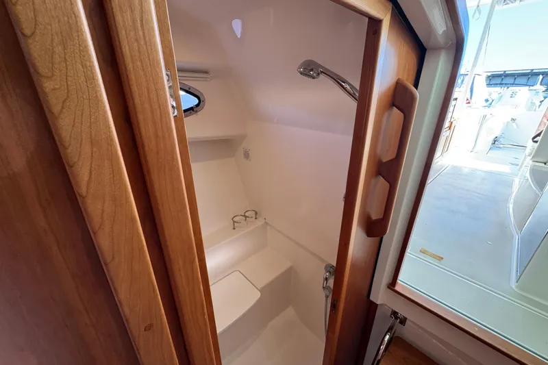  Yacht Photos Pics 2024 Back Cove 34O boat interior shower with wooden door and modern fixtures.