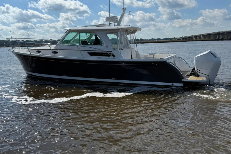  Yacht Photos Pics 2024 Back Cove 34O boat cruising on a sunny day with scenic water backdrop.