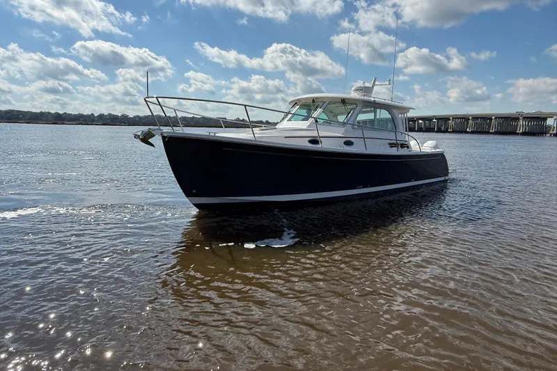  Yacht Photos Pics 2024 Back Cove 34O boat on calm water under a partly cloudy sky.