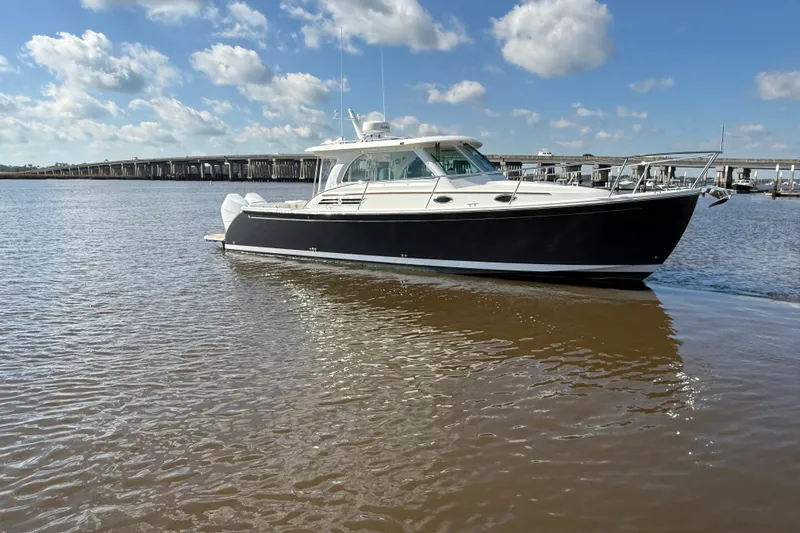  Yacht Photos Pics 2024 Back Cove 34O boat on calm water under a blue sky.