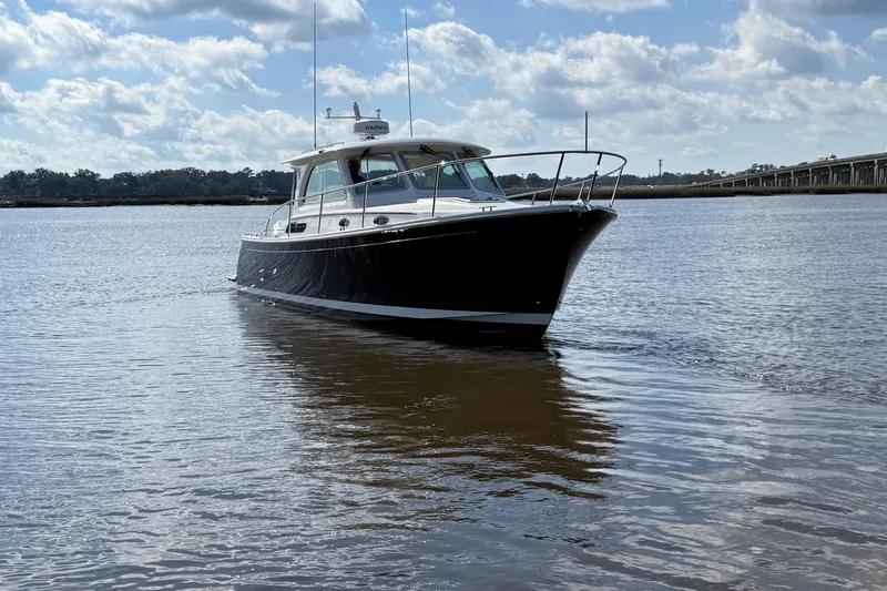  Yacht Photos Pics 2024 Back Cove 34O boat on calm water under a partly cloudy sky.