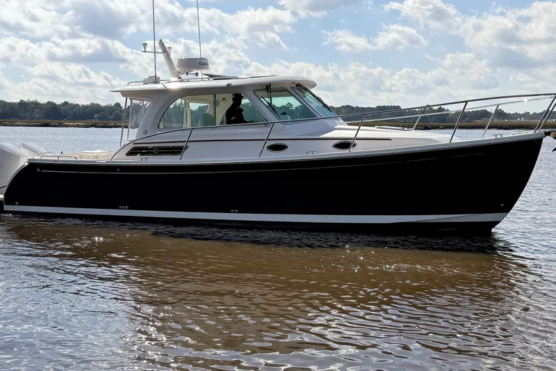  Yacht Photos Pics 2024 Back Cove 34O boat on calm water under a partly cloudy sky.