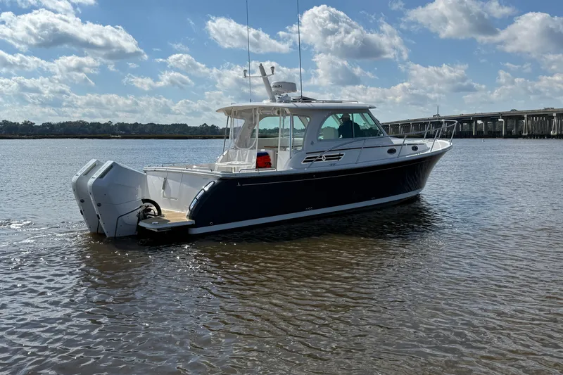  Yacht Photos Pics 2024 Back Cove 34O boat on calm water under a partly cloudy sky.