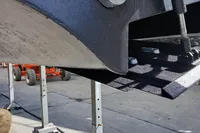 Close-up of a Custom Line 94 yacht hull, 2004 model, supported by metal stands.