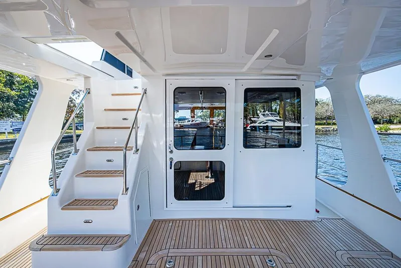 Hayride Yacht Photos Pics Grand Banks 43 Europa 2013 yacht with teak deck and staircase, docked by the water.