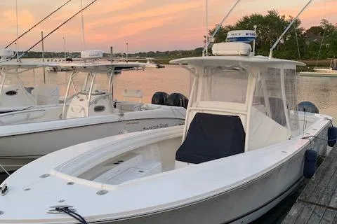  Yacht Photos Pics 2017 Regulator 31 boat docked at sunset with calm waters and trees in the background.