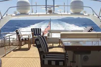 Luxurious Custom Line 94 yacht deck with striped chairs, ocean view, and clear sky, 2004 model.