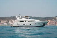 Luxury yacht Custom Line 94, 2004 model, cruising near coastal town.