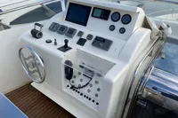 Control panel of a 2004 Custom Line 94 yacht with navigation instruments and steering wheel.