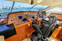 Luxurious yacht helm with advanced controls, Custom Line 94, 2004 model, overlooking marina.