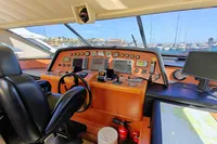 Luxurious yacht cockpit with navigation instruments, leather seats, and marina view. Custom Line 94, 2004.