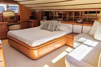 Luxurious 2004 Custom Line 94 yacht bedroom with elegant wood finish and cozy seating area.