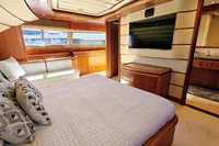 Luxurious yacht bedroom with wood paneling, large bed, and modern amenities, Custom Line 94, 2004.
