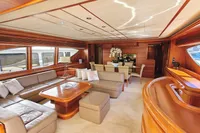 Luxurious yacht interior with elegant wood finishes, plush seating, and large windows. Custom Line 94, 2004.