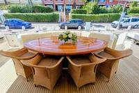 Luxurious yacht deck with wicker chairs and polished wooden table, Custom Line 94, 2004 model.