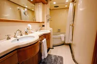Luxurious bathroom in a 2004 Custom Line 94 yacht, featuring dual sinks and a bathtub.