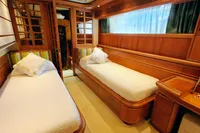 Luxurious twin cabin interior of 2004 Custom Line 94 yacht, featuring elegant wood finishes.