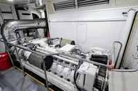 Engine room of a 2004 Custom Line 94 yacht, featuring a large, white engine.